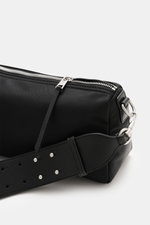 Nahaufnahme der Ami Paris Schultertasche 'Marcel' schwarz aus glänzender Microfaser mit Reißverschluss und Ami-De-Coeur-Applikation, seitliche Perspektive.