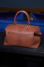 Front view of the Serapian Weekender brown travel bag, showcasing its butter-soft Napa leather in exclusive 'Mosaico' weaving, silver hardware, robust handles, two-way zip, and embossed logo, designed for business and leisure travel.