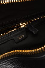 Nahaufnahme des Innenraums vom Tom Ford Weekender schwarz mit goldfarbenem XXL-Reißverschluss, genarbtem Kalbleder und Textilfutter.