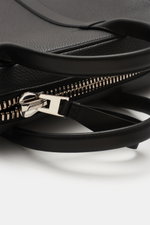 Close-up front-side view of the Tom Ford Briefcase black/silver showing grained calfskin, smooth leather handles, and silver oversized zipper hardware.

<p>Simple design with distinctive leather and XXL hardware make this elegant briefcase a luxurious mus