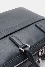 Nahaufnahme der Serapian Aktentasche dark navy aus markant genarbtem Evoluzione-Kalbsleder, schräg von oben fotografiert mit sichtbaren robusten Griffen und anthrazitfarbener Hardware.