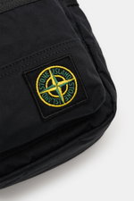 Stone Island Crossbody Bag 'Marsupio Tracolla' schwarz close-up from a top-side angle showing black cotton poplin fabric with iconic yellow-green Windrosen patch. <p>Praktisch und stylish zugleich: Die Crossbody Bag 'Marsupio Tracolla' von STONE ISLAND au