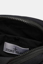 Close-up inside view of the Stone Island Crossbody Bag 'Marsupio Tracolla' schwarz showing the interior label and black cotton popeline fabric with a zipper. Practical and stylish crossbody bag made from pure cotton popeline with aluminium membrane, adjus
