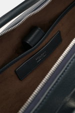 Nahaufnahme der geöffneten Serapian Aktentasche dark navy mit butterweichem, genarbtem Kalbleder, silberfarbenem Reißverschluss und braunem Textilfutter, Blick ins Hauptfach mit Logo-Prägung und Steckfächern.
