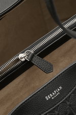 Close-up interior view of Serapian Shopper schwarz showing black cashmere leather with silver zipper and hardware, logo embossing, and beige suede lining. Für diesen luxuriösen Shopper verwendet SERAPIAN feinste Cashmere-Leder-Qualität und veredelt ihn ku