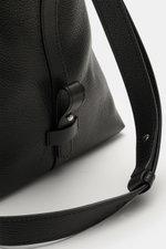 Close-up side view of the Serapian Shopper schwarz in black cashmere leather with grained texture, silver hardware, robust handles, adjustable shoulder strap, and logo embossing, showcasing detailed craftsmanship. Für diesen luxuriösen Shopper verwendet S