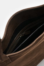 Innenansicht der 04651/ A trip in a bag Tote-Bag dunkelbraun aus markant genarbtem Nubukleder, mit Reißverschluss-Innenfach und schwarzem Futter.