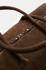 04651/ A trip in a bag Weekender '3-Day-Bag' dunkelbraun aus Veloursleder, Nahaufnahme von oben mit Griffen, Reißverschluss und Prägung.