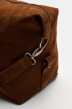 Nahaufnahme des 04651/ A trip in a bag Weekender '3-Day-Bag' braun aus Veloursleder mit silberfarbener Hardware und verstellbarem Schulterriemen.