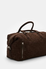 Officine Creative Weekender dunkelbraun aus handgewebtem Veloursleder mit matter, silberfarbener Hardware, robusten Griffen, Reißverschluss und Außenfach, seitliche Perspektive.