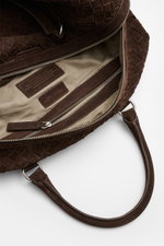 Officine Creative Weekender dunkelbraun aus handgewebtem Veloursleder, offene Perspektive auf Innenfach mit Zipper, robuster Tragegriff, seidenmatte silberne Hardware.