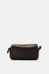 Officine Creative Toiletries bag dark brown shown from the front, featuring plaited leather outer, silver hardware, zippered outside compartment, spacious main compartment, and practical leash, dimensions approx. 25x15x10 cm, a practical travel essential 