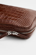 Tom Ford Laptop Sleeve braun aus hochwertigem Kalbleder im Reptilien-Look, Detailaufnahme der silberfarbenen Messing-Reißverschlüsse mit Logo-Prägung.