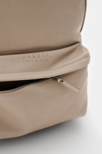 Close-up side view of beige Nubuk leather 04651/ A trip in a bag Rucksack 'Oyster Back Pack' navy showing zipper pocket and logo.