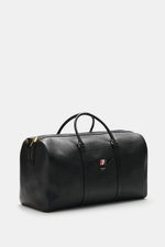 Front-side view of Thom Browne Weekender schwarz in fine grained black leather with gold hardware, sturdy handles, and logo embossed pocket.

<p>Bereit für den nächsten Kurztrip: Der geräumige Weekender von THOM BROWNE aus edlem, fein genarbtem Leder vere