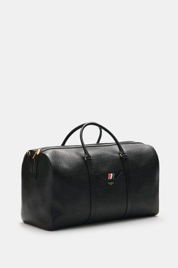 Front-side view of Thom Browne Weekender schwarz in fine grained black leather with gold hardware, sturdy handles, and logo embossed pocket.

<p>Bereit für den nächsten Kurztrip: Der geräumige Weekender von THOM BROWNE aus edlem, fein genarbtem Leder vere