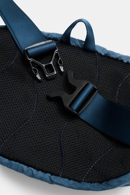 Close-up of the back and adjustable strap buckle of the C.P. Company Belt bag grey blue, photographed from above, showing padded mesh back and robust loop.

Description: Always with you on excursions and in the city is the compact, garment-dyed belt bag m