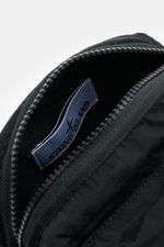 Close-up top view of the Stone Island Crossbody Bag 'Marsupio Tracolla' black showing the interior label, high-quality microfiber, and zipper. Practical and stylish at the same time: The Crossbody Bag 'Marsupio Tracolla' by STONE ISLAND impresses with mul
