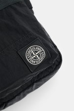 Close-up angled view of Stone Island Crossbody Bag 'Marsupio Tracolla' black showing high-quality microfiber, signature patch, and sturdy stitching, highlighting its multiple compartments and adjustable strap, compact size approx. 16x19x5 cm, practical fo