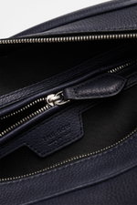 Close-up top view of The Row Crossbody bag 'Jerome' navy showing finely grained leather, silver zipper, embossed logo, and smooth cotton lining. Stylish eye-catcher from THE ROW: The practical crossbody bag impresses with timeless design and becomes the i