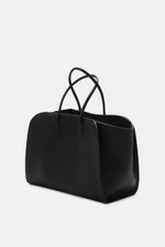 The Row Tote bag 'Marlo' black shown from a front-side angle, made of finely grained leather with spacious compartments.

<p> Stylish all-rounder by THE ROW: The practical tote bag impresses with timeless design and offers plenty of space for all importan