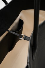 Close-up inside view of The Row Tote bag 'Marlo' black, showing finely grained leather, soft cotton lining, and inner pockets from a top perspective.