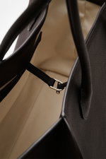Close-up top-down view inside The Row Tote bag 'Marlo' dark brown, showing finely grained leather, soft cotton lining, and interior strap with silver buckle. Stylish all-rounder by THE ROW: The practical tote bag impresses with timeless design and offers 