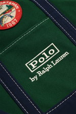 Nahaufnahme des Polo Ralph Lauren Shopper dunkelgrün/navy aus Canvas mit Stick-Logo, Patch-Details und navy Textil-Tragegriff, Frontperspektive.