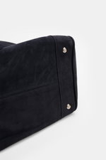 Nahaufnahme der unteren Ecke des Weekender '356 Bag' navy von 04651/ A trip in a bag aus Veloursleder mit Metallfüßchen und silberfarbener Hardware.