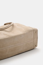 Nahaufnahme des Bodens mit schonenden Metallfüßchen des 04651/ A trip in a bag Weekender '356 Bag' beige aus geschmeidigem Veloursleder.