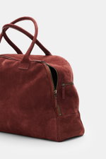 04651/ A trip in a bag Weekender '356 Bag' rotbraun aus Veloursleder, seitliche Nahaufnahme mit Reißverschluss, robusten Griffen, silberfarbener Hardware, Maße ca. 56x35x21 cm.