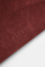 Nahaufnahme des rotbraunen Veloursleders mit geprägtem Schriftzug des 04651/ A trip in a bag Weekender '356 Bag' in leichter Schräge.