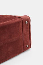 04651/ A trip in a bag Weekender '356 Bag' rotbraun aus Veloursleder, Detailaufnahme der Unterseite mit Metallfüßchen, weiches Leder und robuste Nähte.