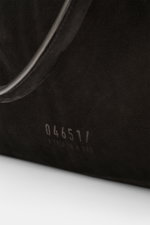 Nahaufnahme des schwarzen 04651/ A trip in a bag Weekender '356 Bag' aus Veloursleder mit sichtbarem Logo und Tragegriff, Detailansicht.