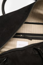 Nahaufnahme des geöffneten Weekender '356 Bag' schwarz von 04651/ A trip in a bag, zeigt Innenfutter, Reißverschluss und Adressfach aus Veloursleder.