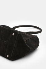 Nahaufnahme des schwarzen 04651/ A trip in a bag Weekender '356 Bag' aus Veloursleder in Seitenansicht mit silberfarbener Hardware und robusten Tragegriffen.