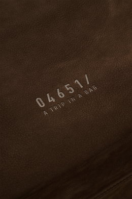 Nahaufnahme des dunkelbraunen Veloursleders mit silberner 04651/-Prägung des 04651/ A trip in a bag Weekender '356 Bag'.
