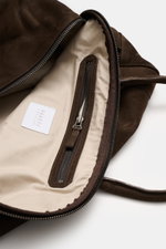 Innenansicht des geöffneten 04651/ A trip in a bag Weekender '356 Bag' dunkelbraun aus Veloursleder mit beigem Textilfutter, Zipper-Fach und Prägung.