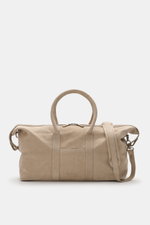 Beige Weekender "04651/ A trip in a bag Weekender '3 Day Bag'" aus Nubukleder, silberne Hardware, robuste Griffe, Zwei-Wege-Reißverschluss, Frontprägung, seitlich mit Schulterriemen, fotografiert von vorne.