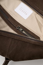 Close-up interior view of the 04651/ A trip in a bag Weekender '3 Day Bag' dark brown showing textile lining, zipper pocket, and embossed label with soft nubuck leather, silver-colored hardware, robust carrying handles, two-way zipper, small address compa