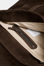 Detailansicht des Innenraums vom dunkelbraunen 04651/ A trip in a bag Rucksack 'Hybrid Tote' aus weichem Nubukleder mit Zipper-Innenfach.