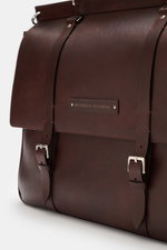 Brunello Cucinelli Weekender dunkelbraun aus edlem Leder, glatte Haptik, silberne Hardware, robuste Tragegriffe, Nahaufnahme Frontansicht.