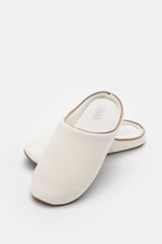 Slipper in cremeweiß mit brauner Paspelierung, aus dem 04651/ A trip in a bag Reise-Set 'Voyage' creme/weiß, seitlich von oben fotografiert, Teil eines Travel-Essentials mit Bademantel, Handtuch, Badetuch, Necessaire, Schlafmaske im Canvas-Shopper.