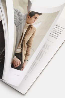 Close-up side view of Edition EDITION Magazin Herbst 2025 showing a man in a beige jacket and white turtleneck, with text about style, tradition, and modern luxury in Salzburg.