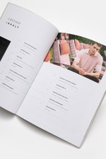 Edition EDITION Magazin Frühling 2026, schräg von oben fotografiert, zeigt geöffnete Inhaltsseite mit Text und Foto eines Mannes in rosafarbenem Polo.
