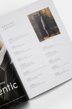 Top-down view of Edition EDITION Magazine Autumn 2026 open to a content page with text and a photo of a man in a coat, showcasing timeless elegance and style.