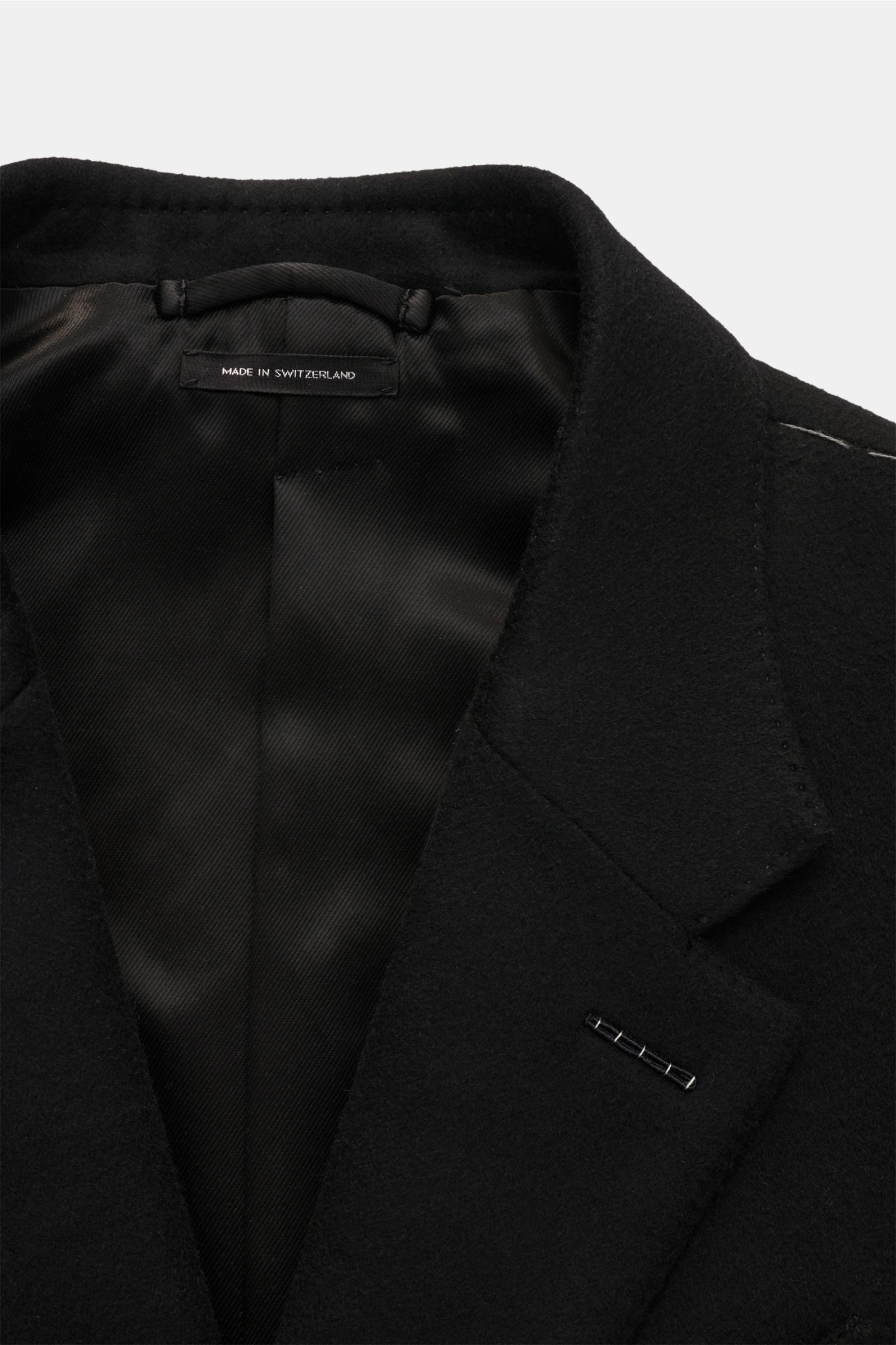 Close-up front view of Tom Ford Mantel schwarz showing black wool-cashmere blend fabric with soft texture and tailored lapel.

Souverän durch die kalte Jahreszeit: Dieser Mantel von TOM FORD aus edlem Woll-Mix mit Cashmere wird von der markentypischen 