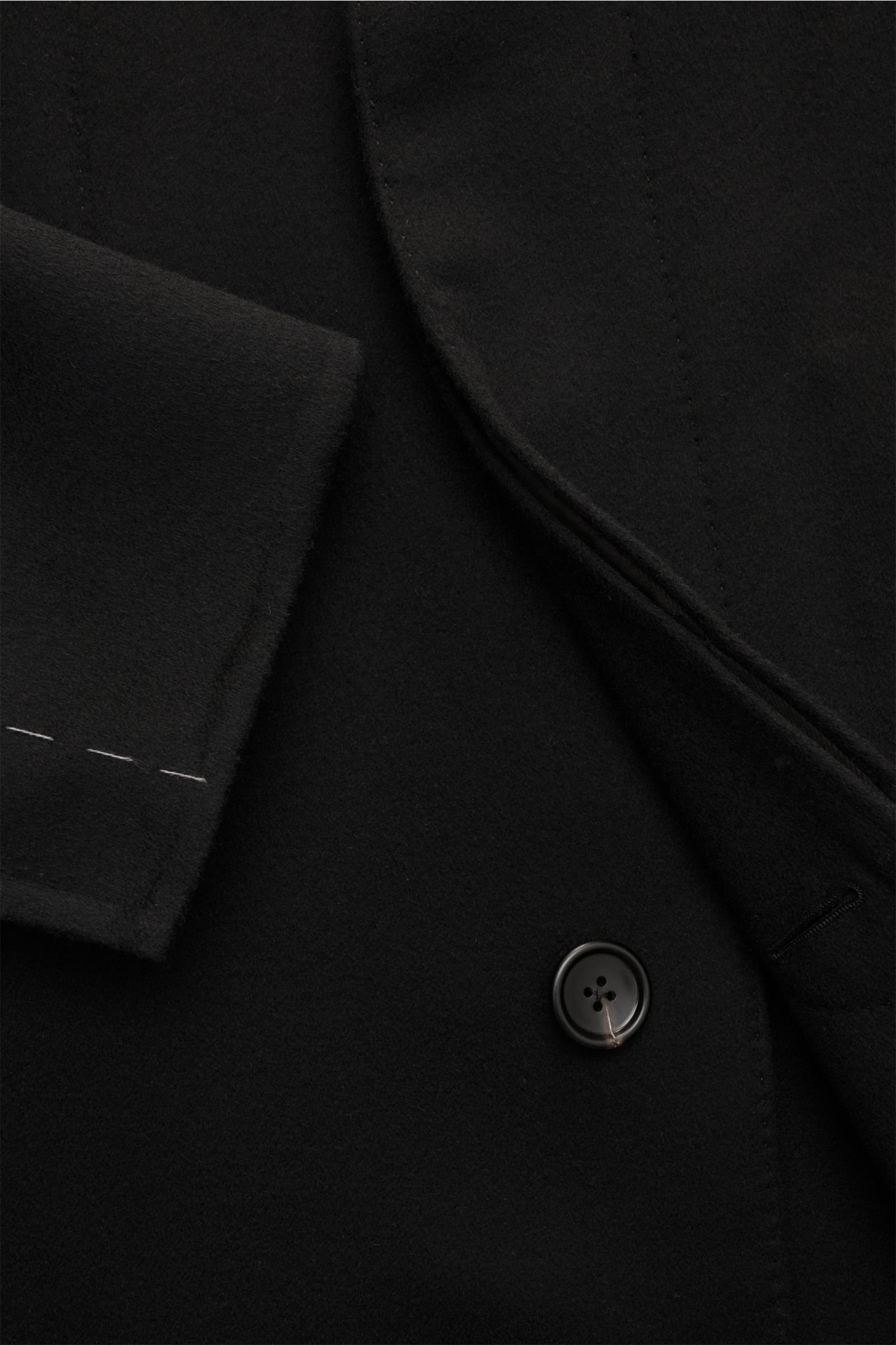Close-up view of the Tom Ford Mantel schwarz showing the slim fit, three-button style, soft wool-cashmere mix fabric, and unfinished sleeve cuffs.

Souverän durch die kalte Jahreszeit: Dieser Mantel von TOM FORD aus edlem Woll-Mix mit Cashmere wird von