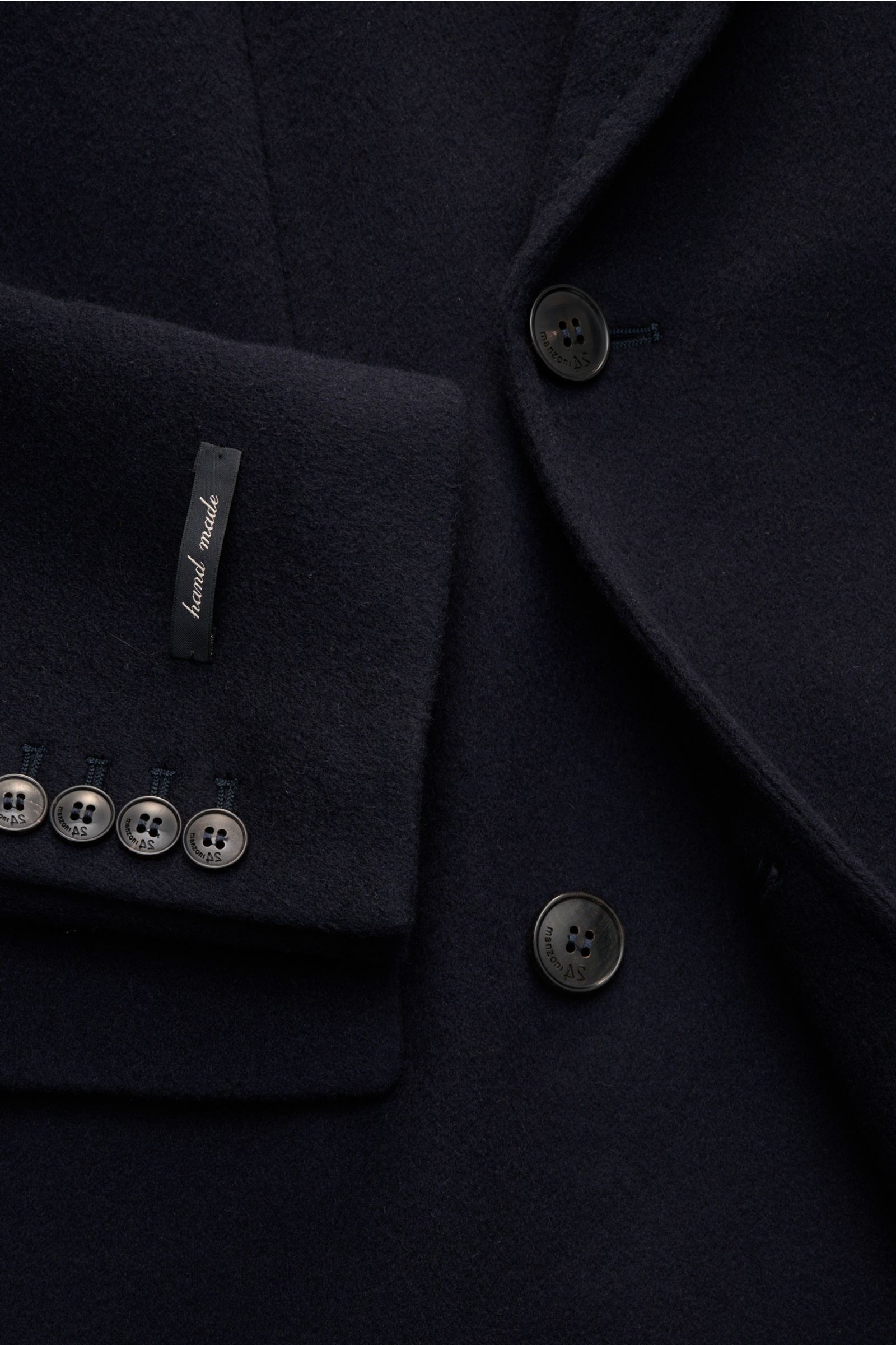 Nahaufnahme von dunkelblauem Manzoni 24 Mäntel - U640 Wollmantel, handgefertigt, mit Knöpfen und Manschette, schräge Frontansicht.