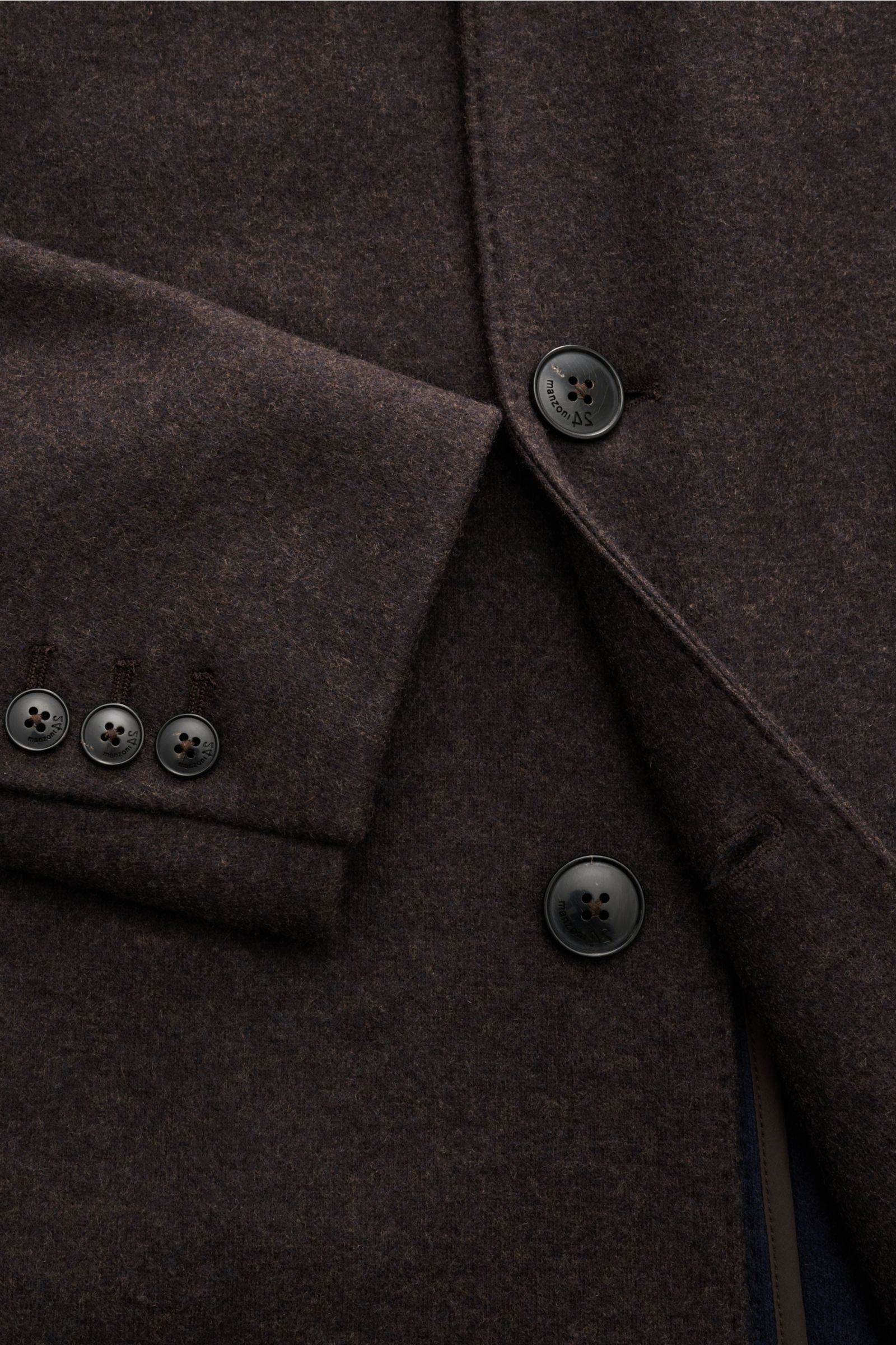 Close-up front view of the Manzoni 24 Kurzmantel dunkelbraun, showcasing its soft cashmere-wool mix, slim fit, three-button closure, and sleeve buttons. Mit seiner Expertise für High-end-Wolle ist LORO PIANA der perfekte Kooperationspartner für das Label 